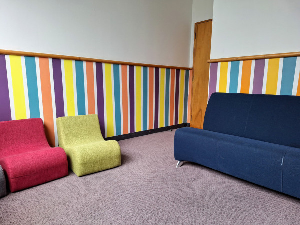 A picture of the quiet room, featuring a sofa and several individual chairs.